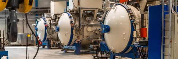 Vakuumiuunin edessä seisova Sten Teräksen asiantuntija valvoo teräskomponenttien lämpökäsittelyä modernissa Muuramen yksikössä.